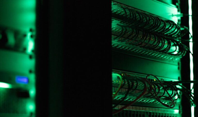 Rack-mounted server equipment glowing in a dark room