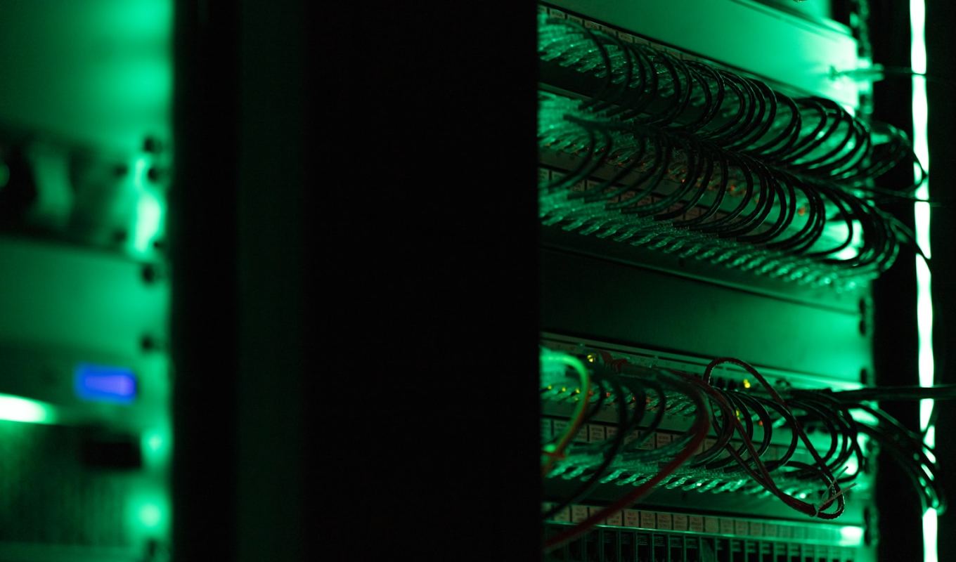 Rack-mounted server equipment glowing in a dark room