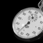 Close-up of a mechanical stopwatch against a black background