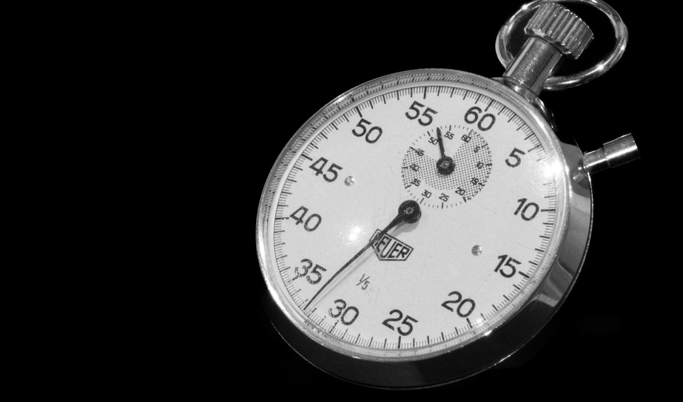 Close-up of a mechanical stopwatch against a black background