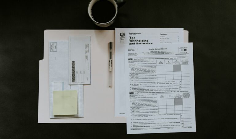 Invoice paperwork and a pen on a desk beside a cup of coffee