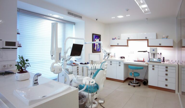 A modern dental treatment room with a chair and clinical equipment