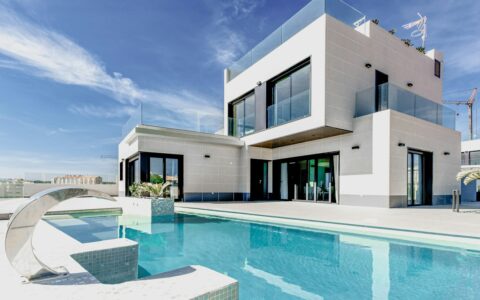A modern white house exterior photographed against a blue sky