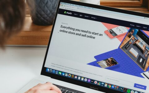 A laptop on a white desk showing an online store being set up